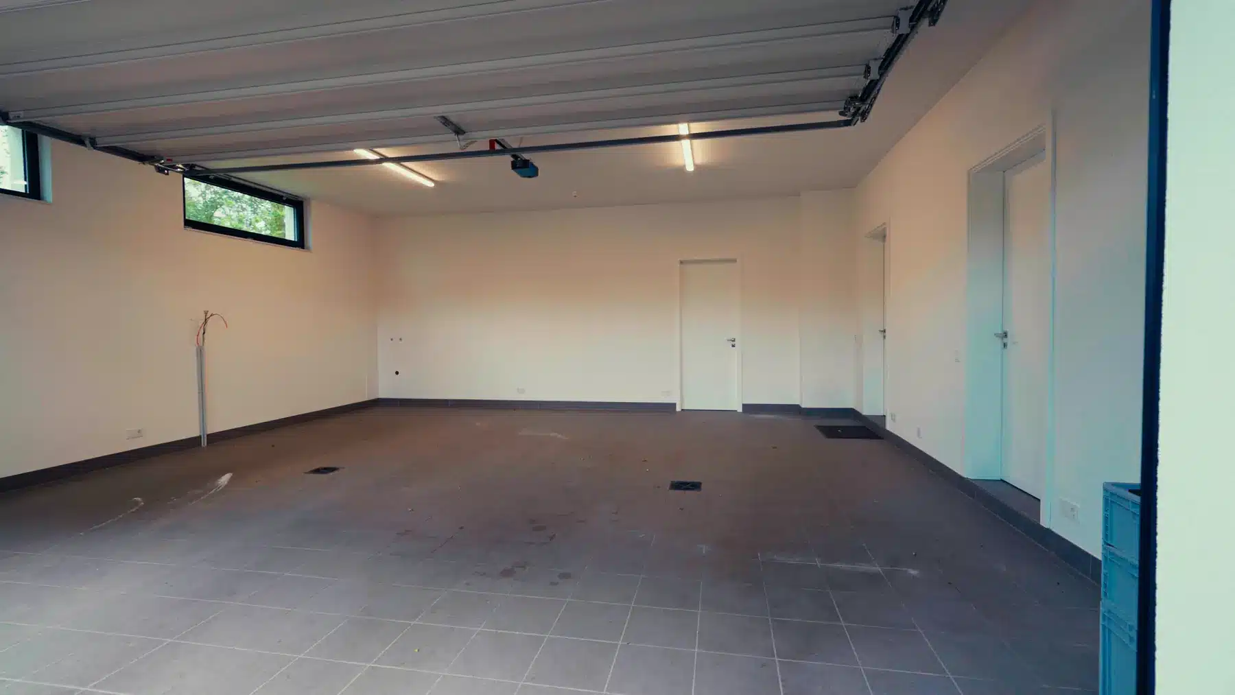 Autogarage vorher: leerer Raum mit grauem Fliesenboden